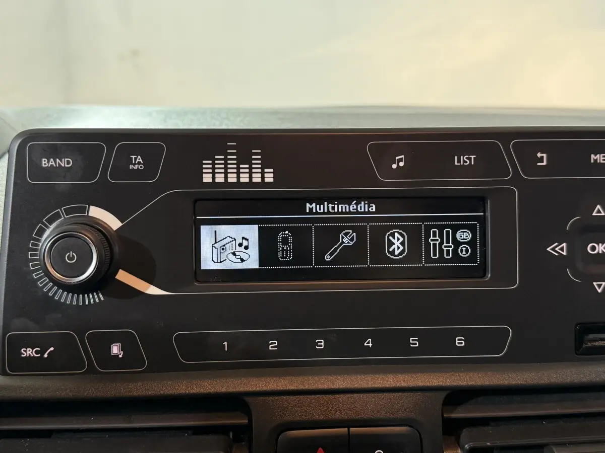 Tableau de bord noir du Peugeot Rifter 2019, affichage multimédia avec options Bluetooth et réglages audio visibles.