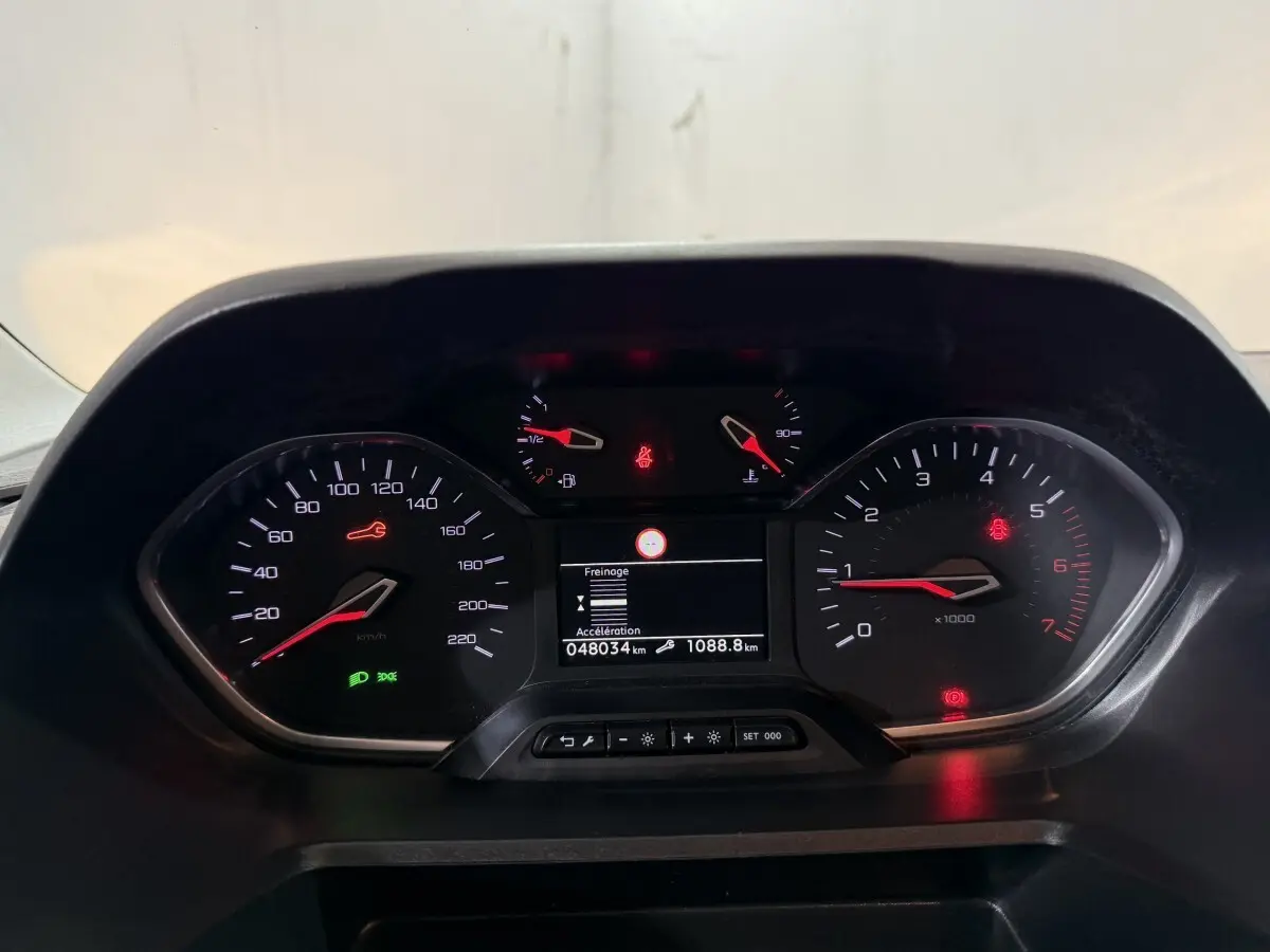 Vue rapprochée du tableau de bord du Peugeot Rifter blanc 2019, affichage digital et compte-tours visibles.