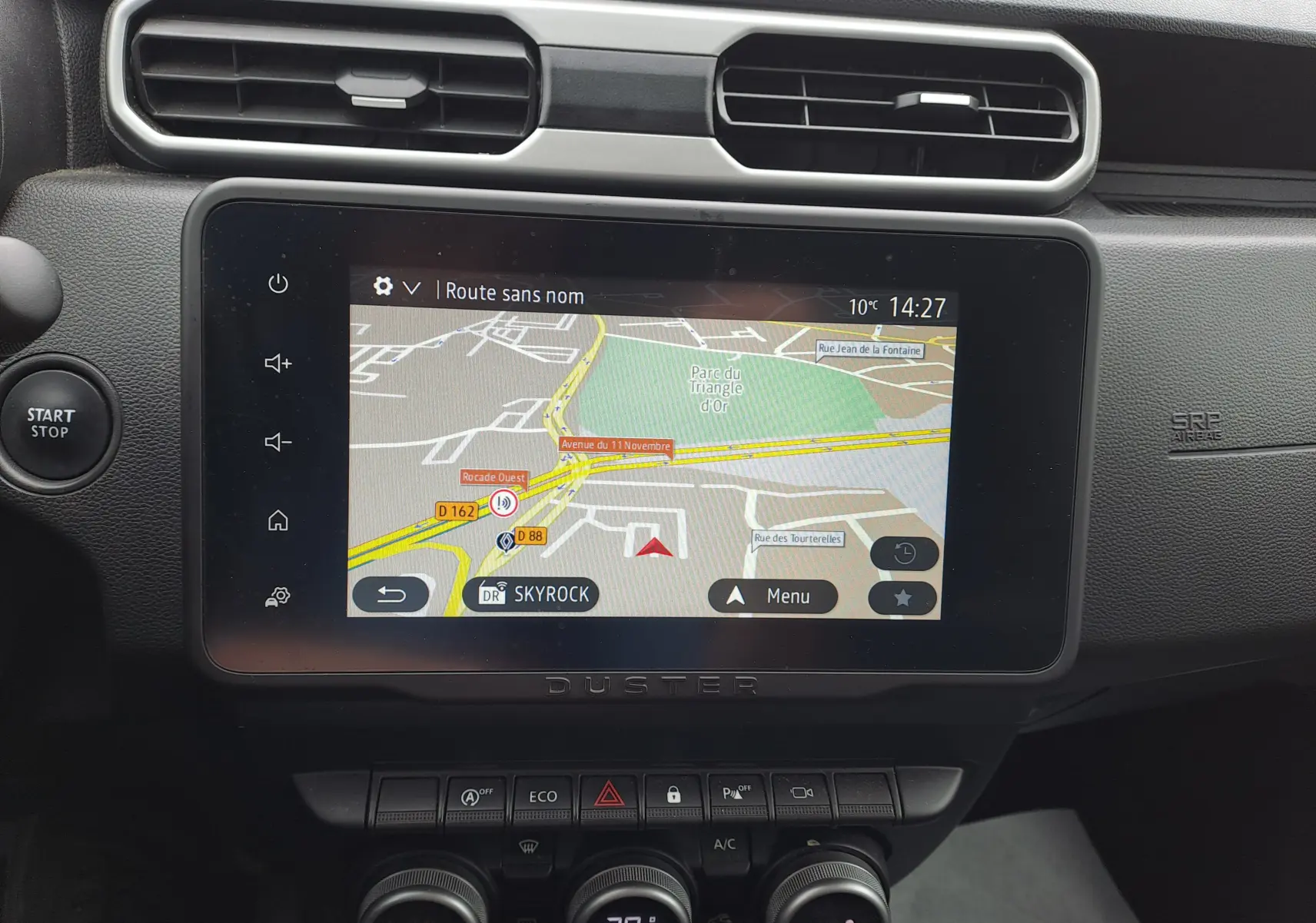 Écran central tactile du Dacia Duster 2024 gris urbain, affichant la navigation GPS avec commandes autour.