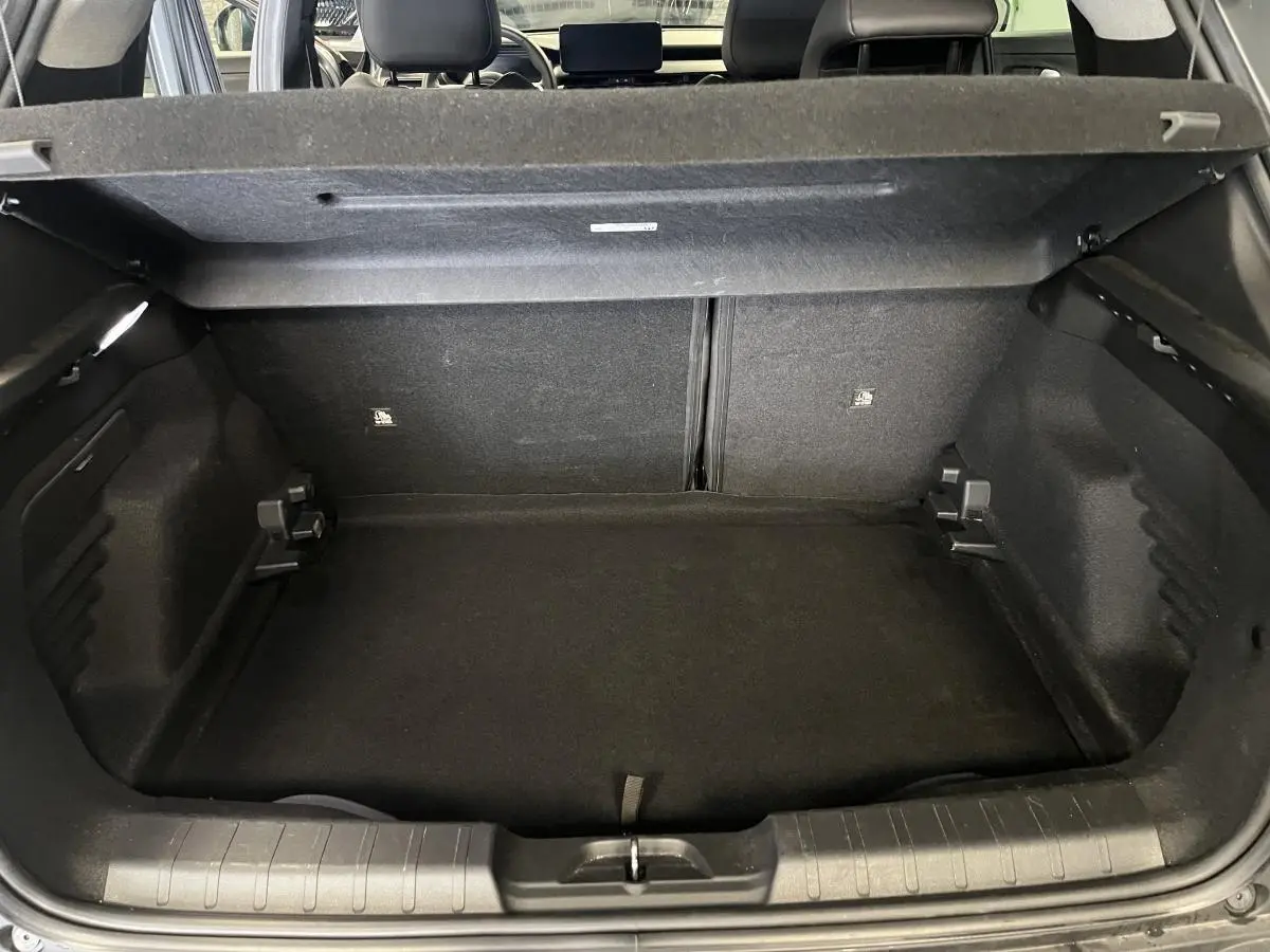 Coffre ouvert du Jeep Avenger gris 2024, vue arrière montrant l'espace de chargement et la banquette arrière.