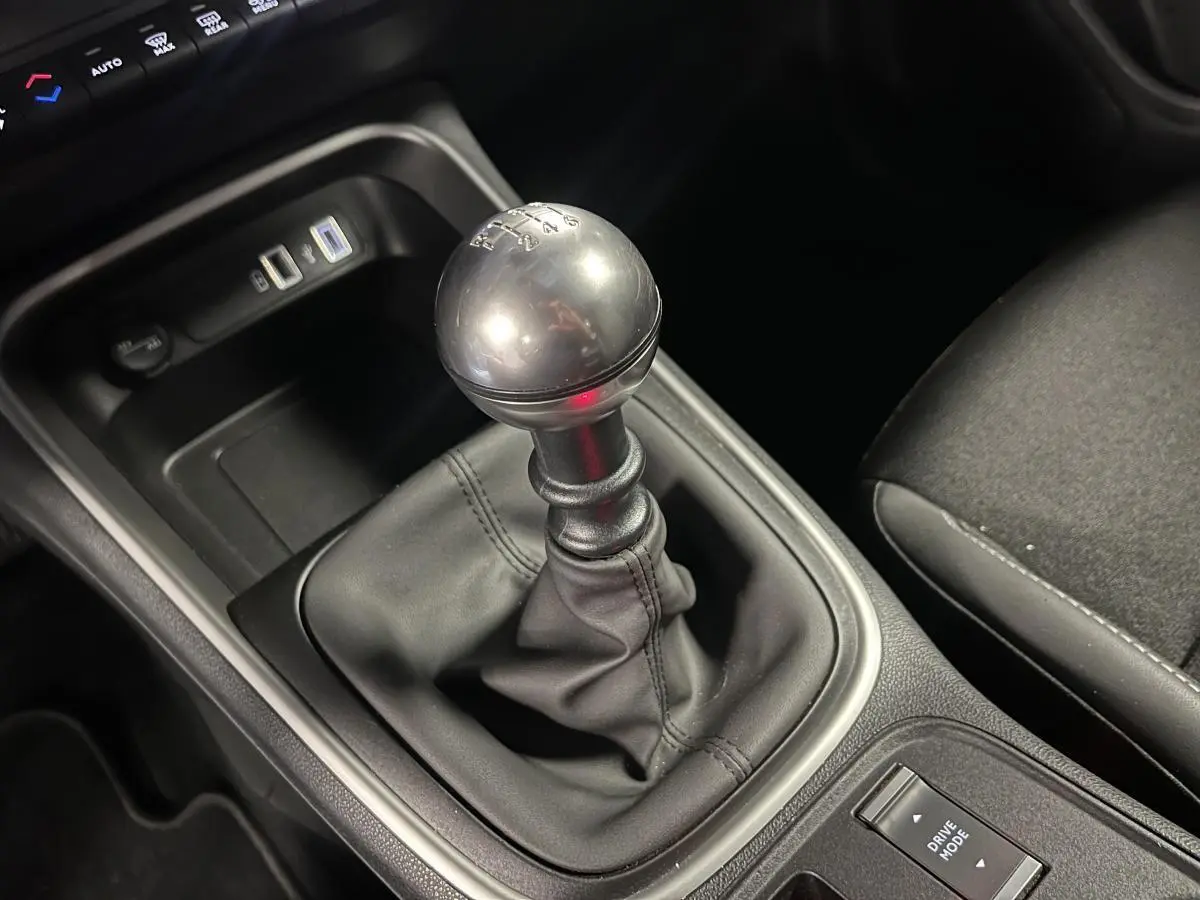 Gros plan sur le levier de vitesses manuel gris métallisé et la console centrale noire du Jeep Avenger 2024.