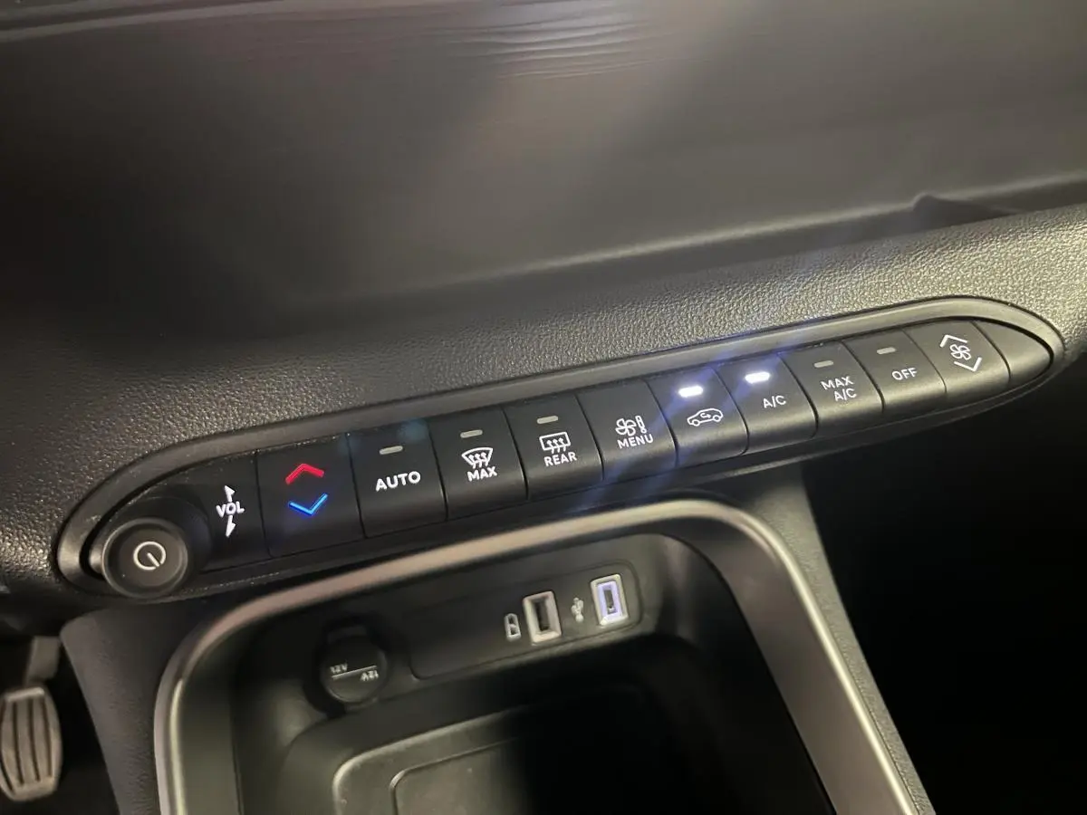 Gros plan sur la console centrale du Jeep Avenger 2024, boutons de climatisation et ports USB visibles.