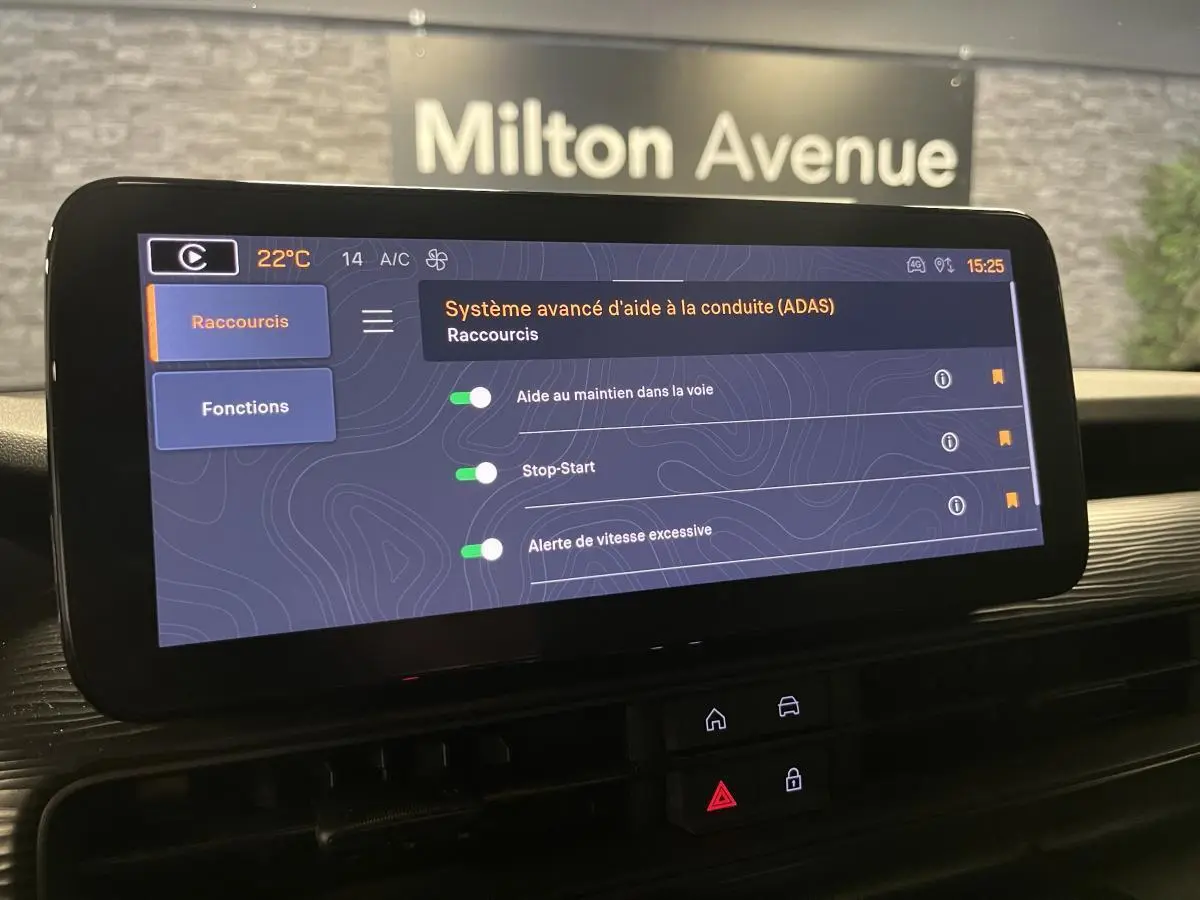 Écran tactile du système multimédia Uconnect 10,25" dans l'habitacle du Jeep Avenger gris, vue de face.