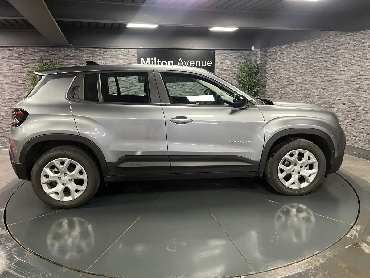 Vue de profil côté gauche du Jeep Avenger 2024 gris métallisé avec jantes alliage 17 pouces et coques de rétroviseurs noires.