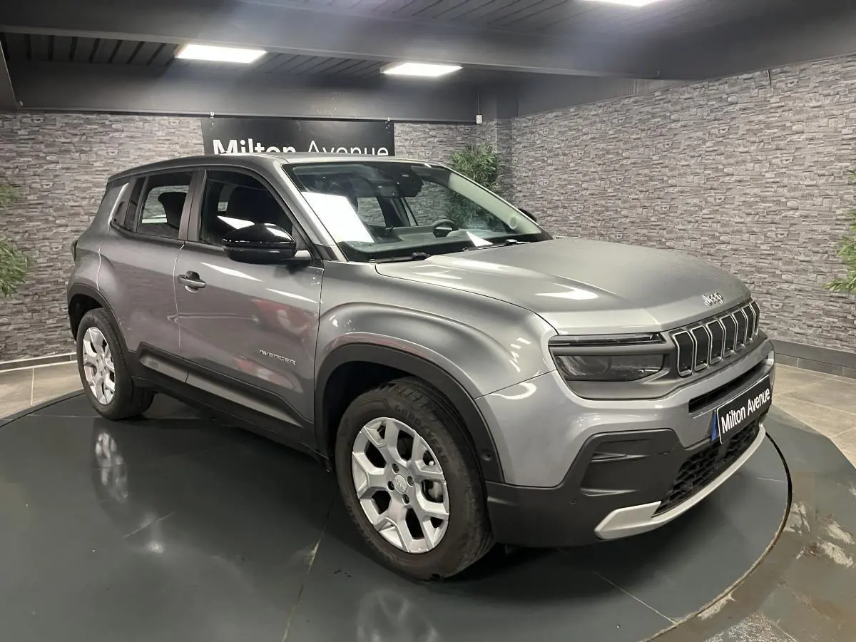 Jeep Avenger gris métallisé en vue 3/4 avant droit, avec calandre distinctive et jantes alliage 17 pouces.