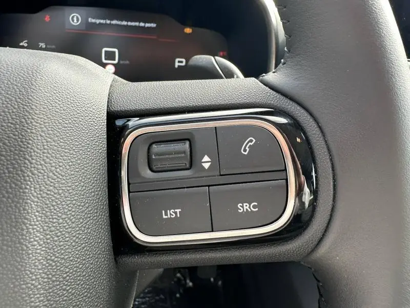Gros plan sur les commandes au volant côté gauche du Citroën C5 Aircross 2025, finition noire avec boutons fonctionnels.