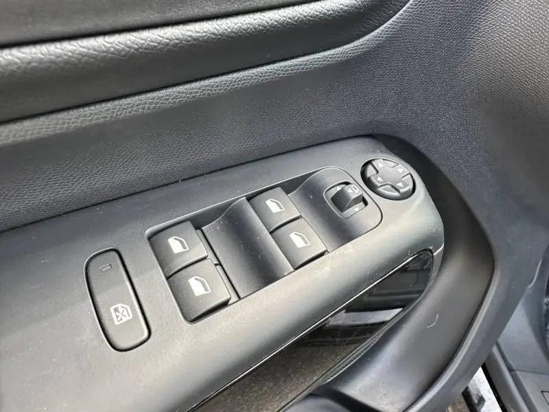 Détail des commandes des vitres et rétroviseurs sur la porte intérieure côté conducteur du Citroën C5 Aircross noir Perla Nera.