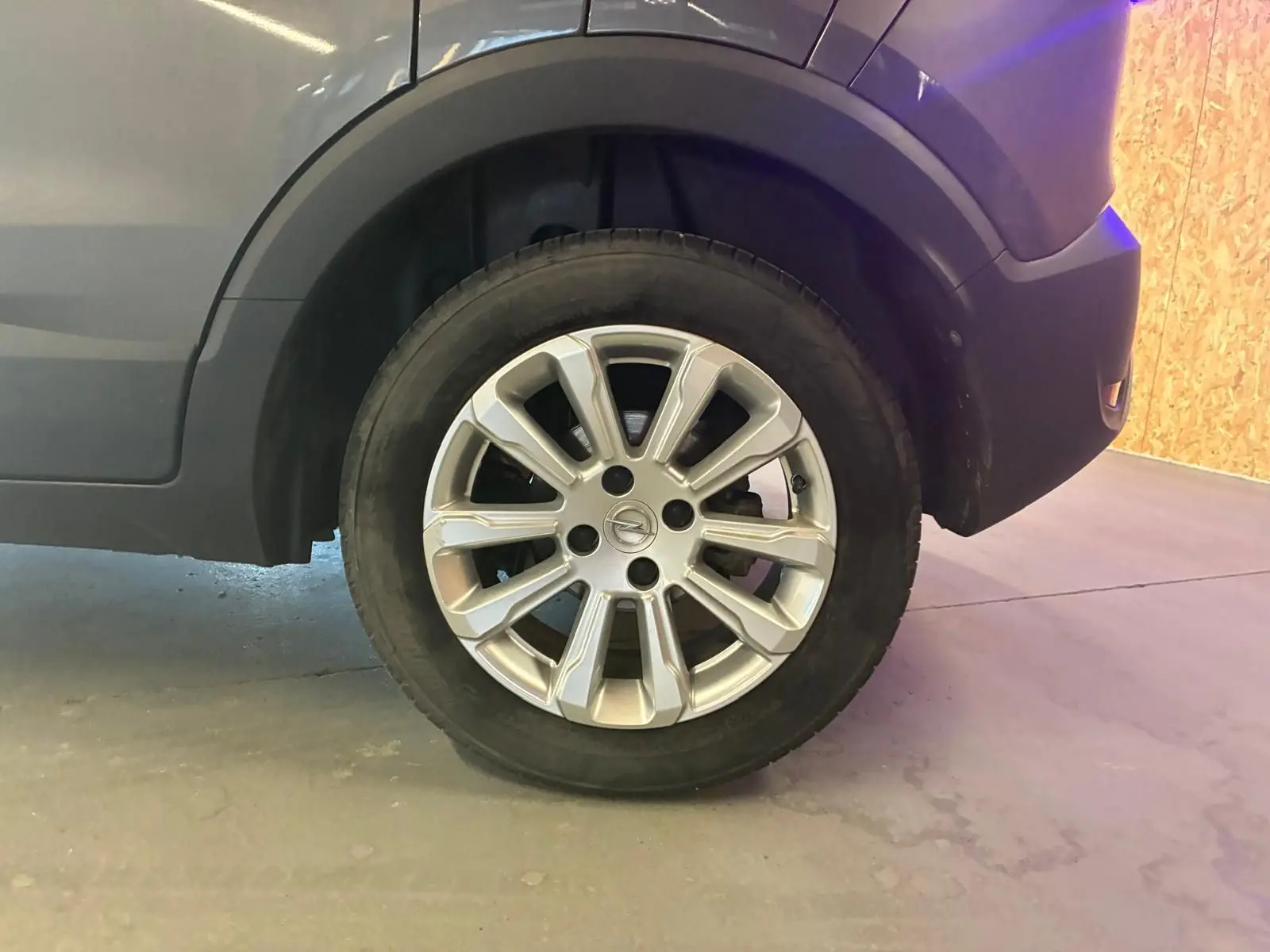 Gros plan sur la roue avant droite grise d’un Opel Crossland 1.2 Turbo 110 Elegance avec jante alliage argentée.