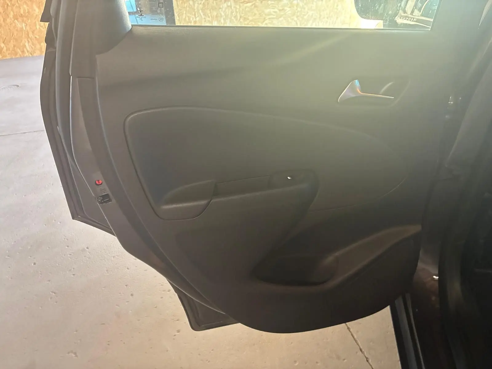 Vue intérieure de la porte arrière gauche noire d'un Opel Crossland 2021, finition tissu gris-noir.