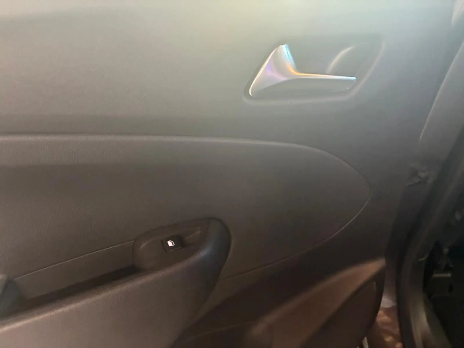 Gros plan sur la porte intérieure côté droit de l’Opel Crossland gris, montrant la poignée argentée et le bouton de verrouillage.
