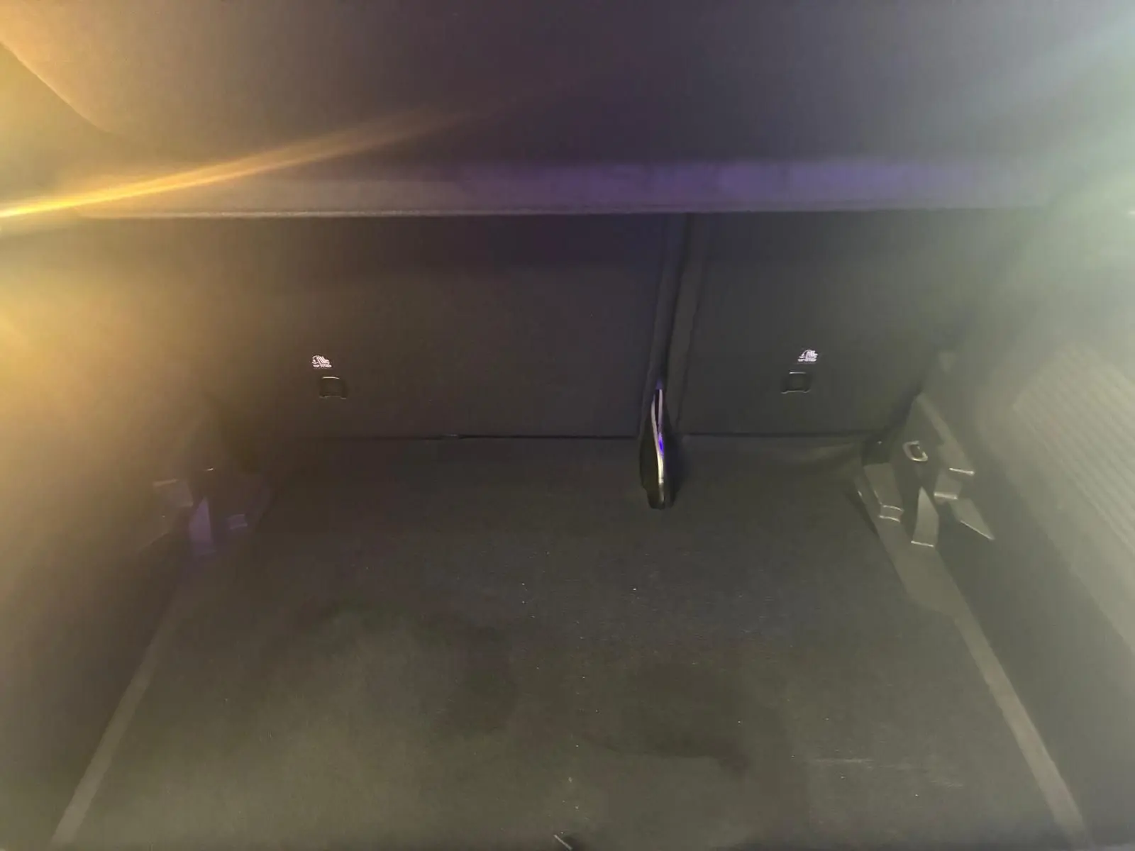 Coffre vide de l’Opel Crossland gris, vue intérieure en plongée montrant le tapis et les fixations arrière.