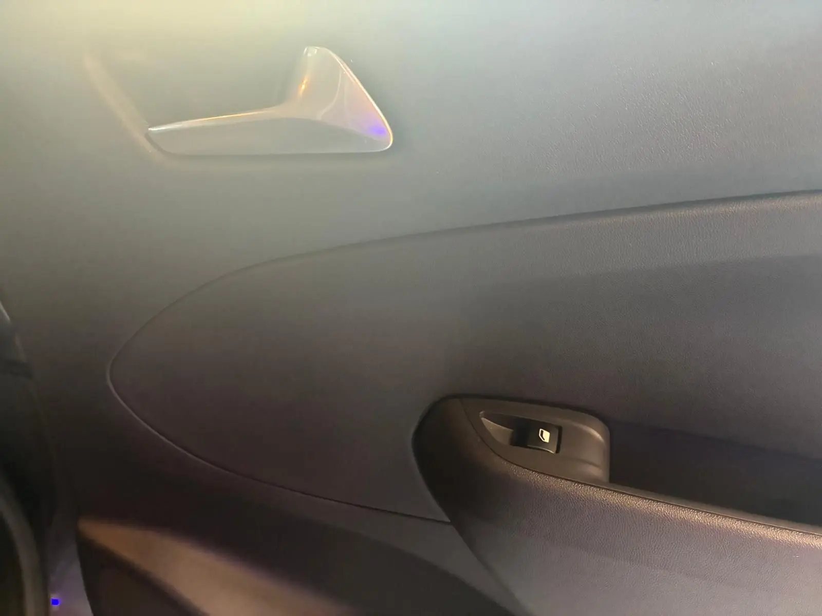 Intérieur côté gauche de la porte d’une Opel Crossland gris, avec poignée de porte et bouton de verrouillage.