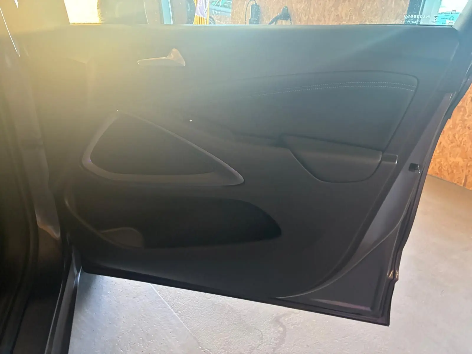 Vue intérieure de la porte arrière droite d'une Opel Crossland gris, avec poignée et panneau en tissu noir.