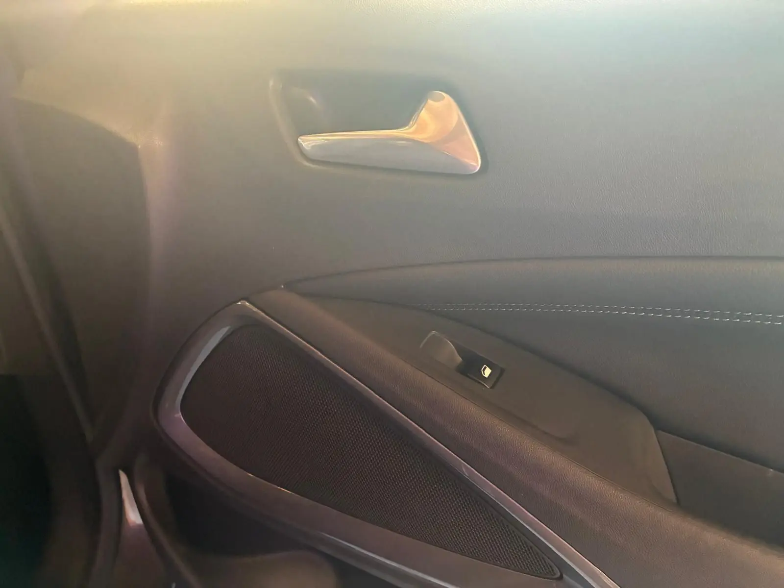 Gros plan sur la poignée intérieure et le panneau de porte côté gauche de l’Opel Crossland gris, finition tissu gris-noir.