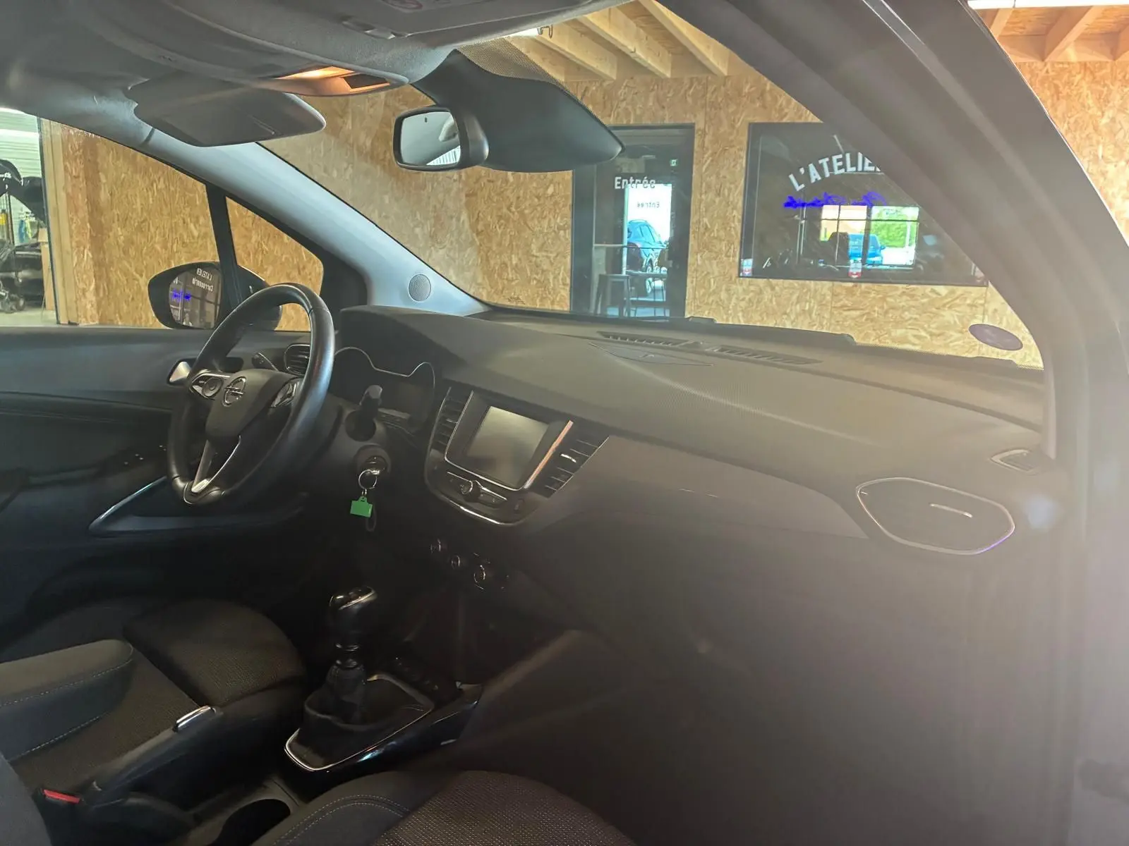 Intérieur de l’Opel Crossland 1.2 Turbo 110 Elegance 2021, vue côté conducteur, tableau de bord gris et volant noir.