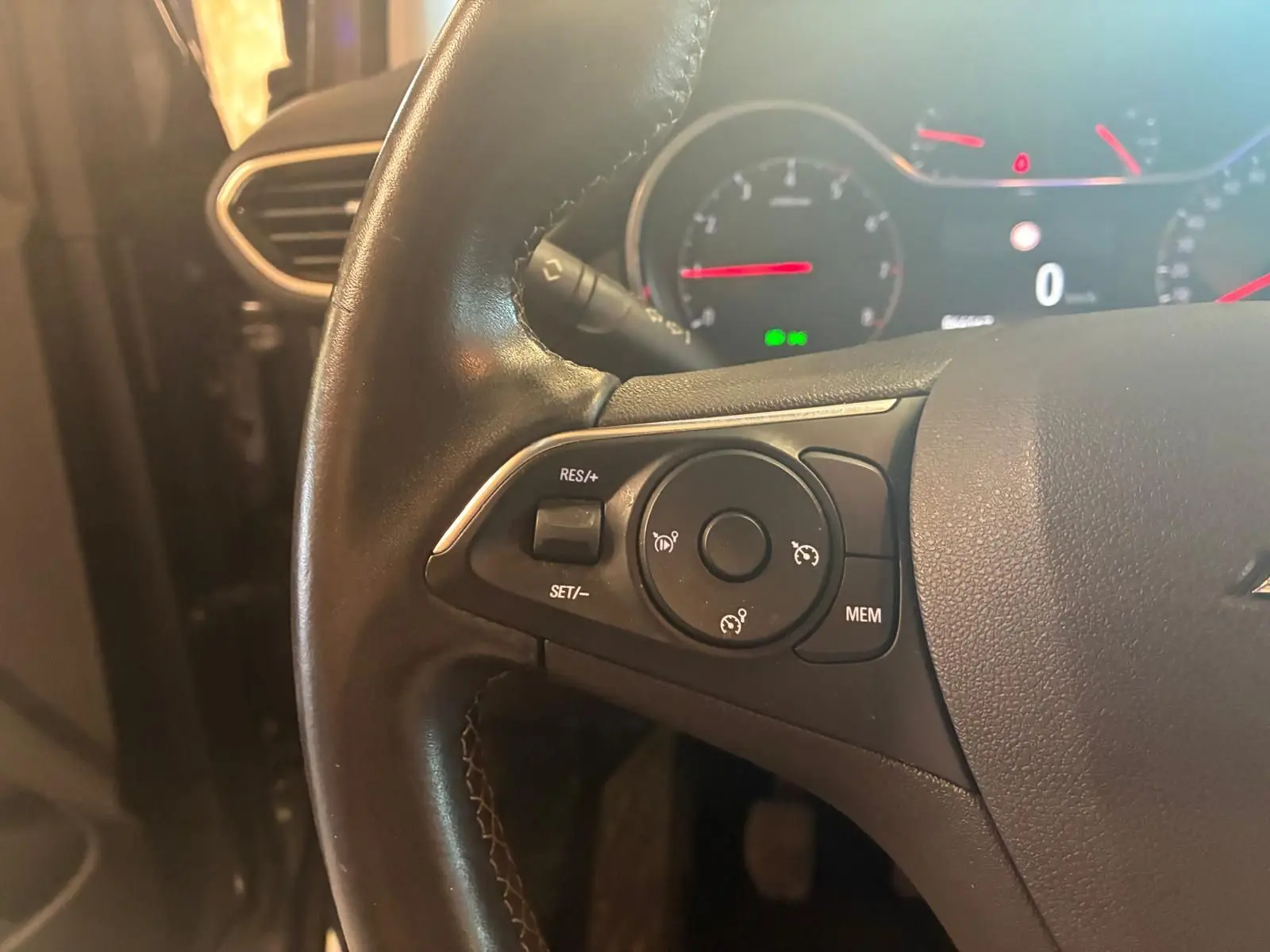 Gros plan sur le volant noir de l'Opel Crossland 2021, montrant les commandes de régulateur de vitesse à gauche.