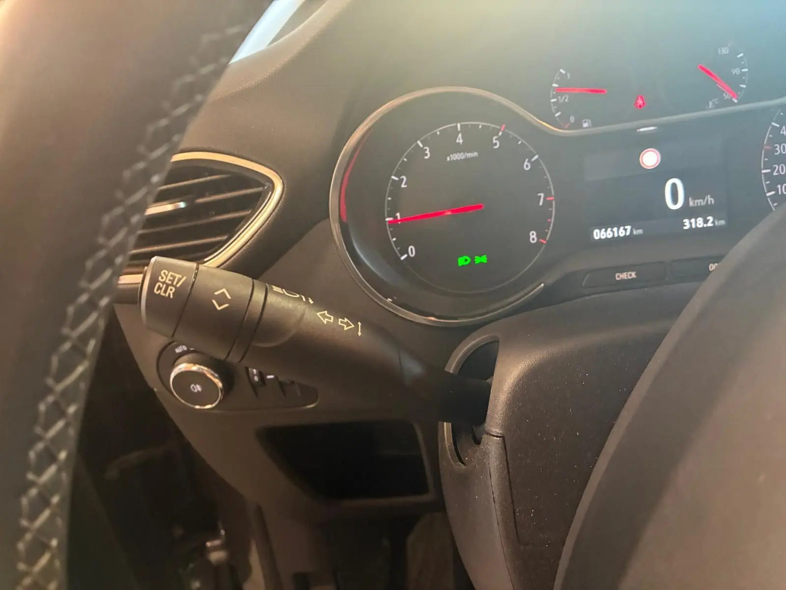Vue rapprochée du tableau de bord de l’Opel Crossland gris, montrant le compteur et la commande de clignotant côté gauche.