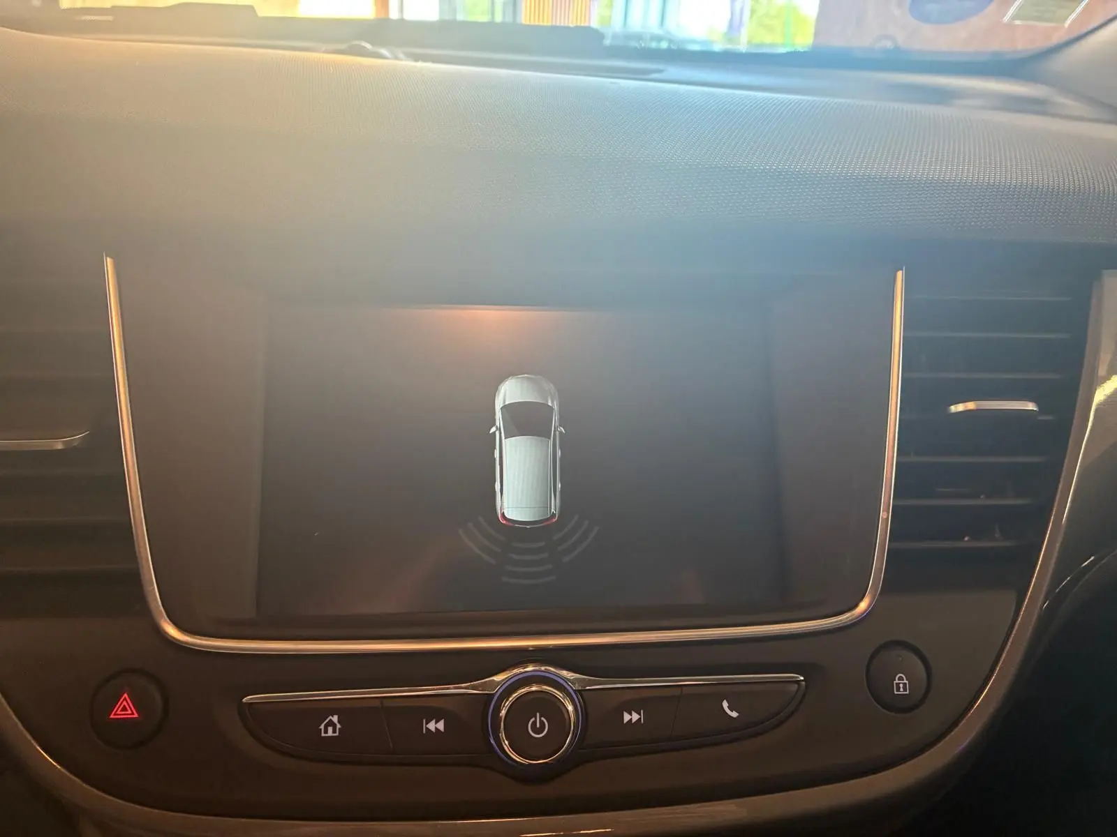 Vue rapprochée de l’écran central du tableau de bord d’une Opel Crossland gris, affichant le système d’aide au stationnement.