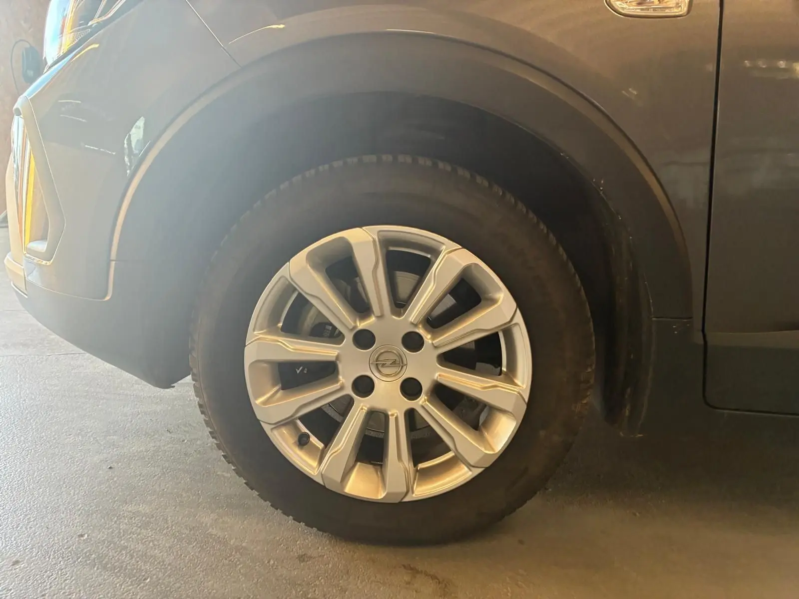 Gros plan sur la roue avant gauche grise d’un Opel Crossland 1.2 Turbo 110 Elegance de 2021.