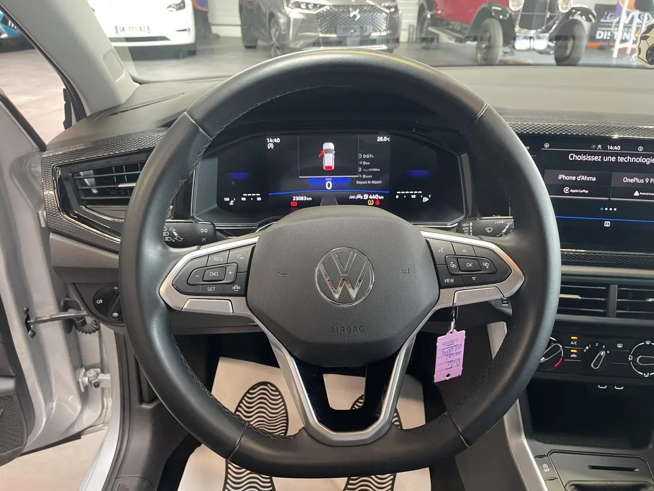 Vue intérieure centrée sur le volant cuir multifonction d'une Volkswagen Polo gris clair 2024 avec tableau de bord numérique.