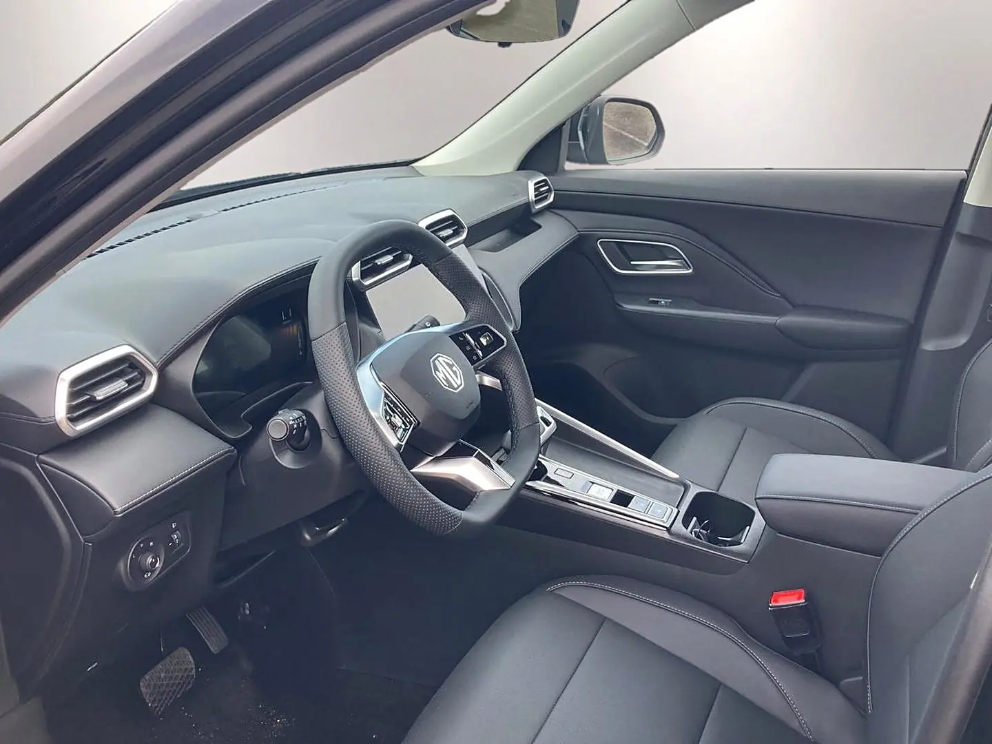 Intérieur noir du MG ZS 1.5 hybrid 197 luxury vu côté conducteur, avec volant multifonction et console centrale moderne.