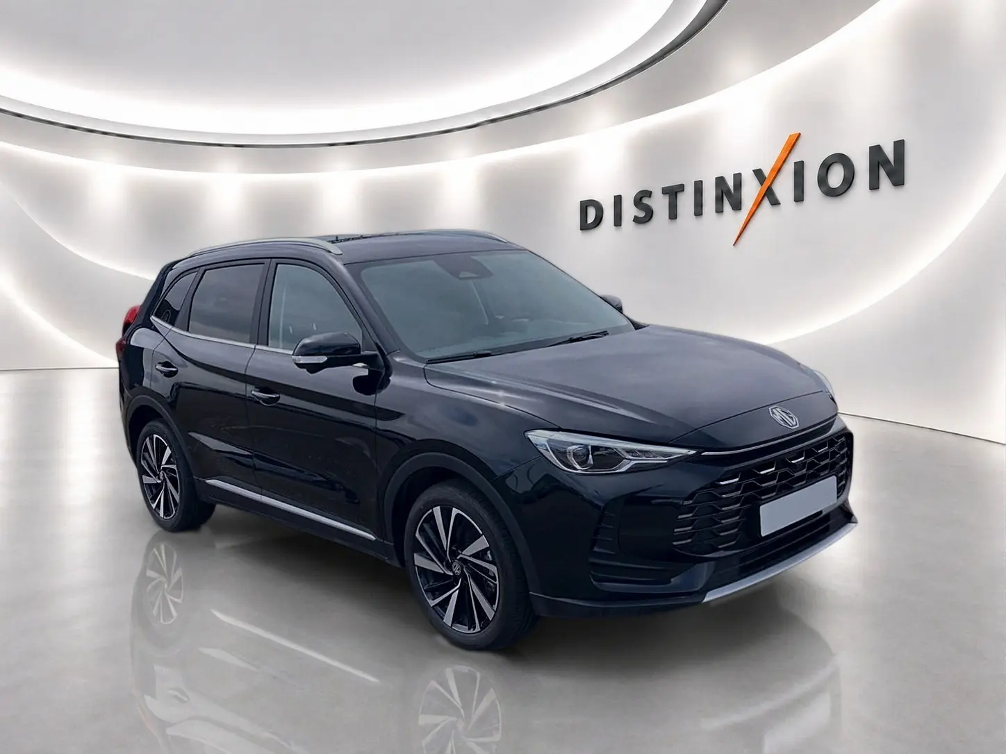 MG Motor ZS 1.5 hybrid 197 luxury noir en 3/4 avant droit, avec jantes alu et toit panoramique en showroom lumineux.