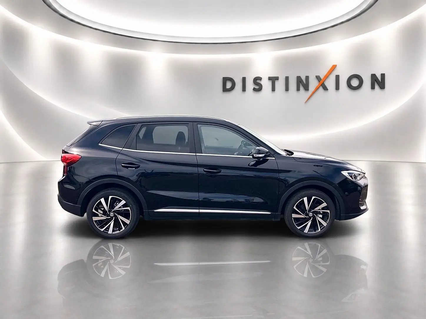 Vue de profil côté gauche du MG Motor ZS 1.5 hybrid noir avec jantes alliage et toit panoramique en studio lumineux.