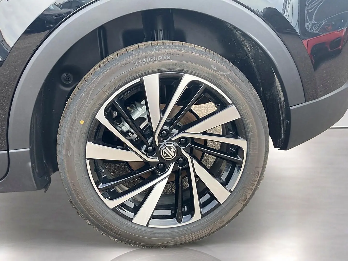 Gros plan sur la roue avant droite noire avec jante alu bicolore du MG Motor ZS 1.5 hybrid 197 luxury 2026.
