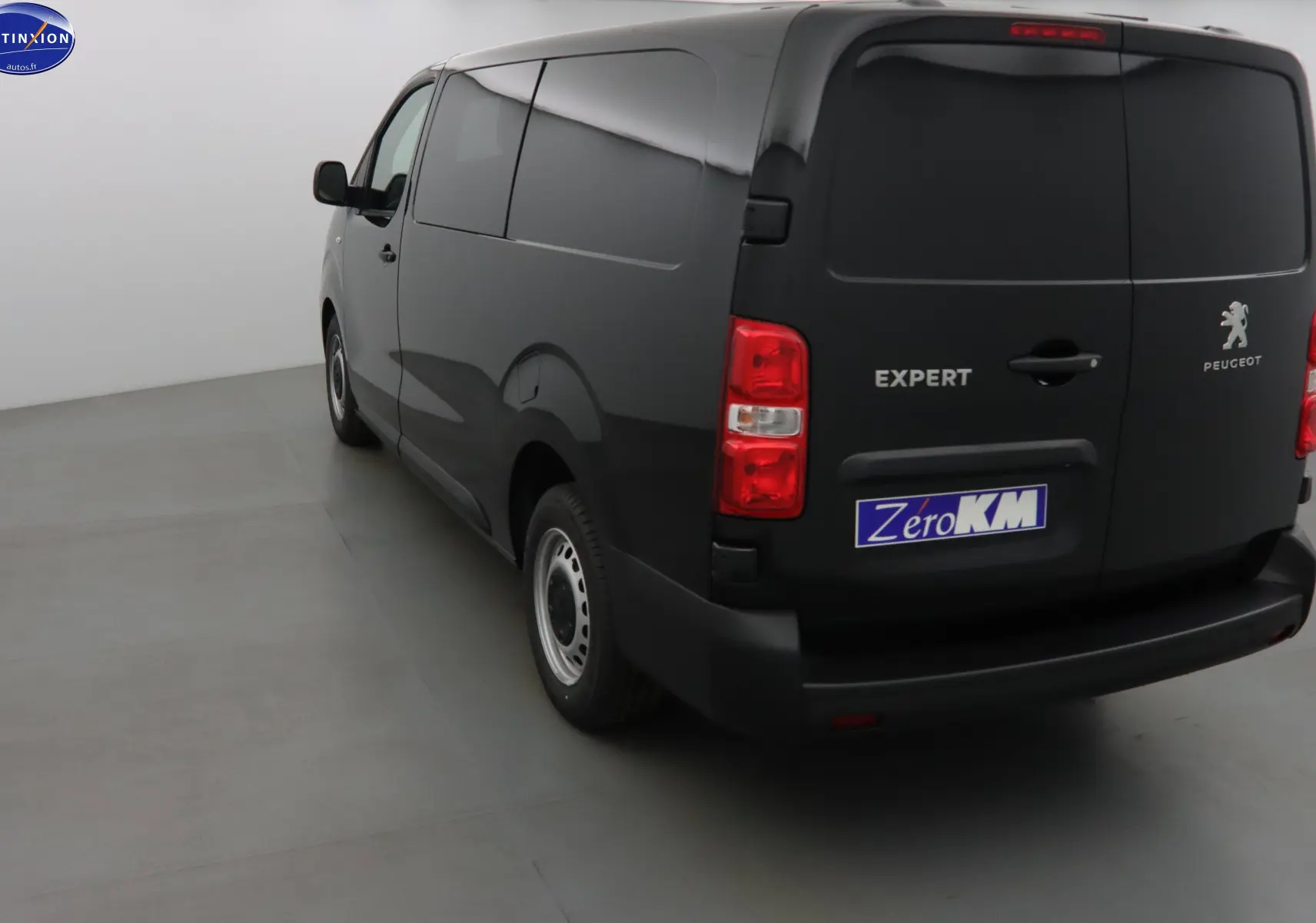 Vue 3/4 arrière gauche d'un Peugeot Expert Cabine Approfondie noir perle métal avec portes arrière fermées dans un studio.