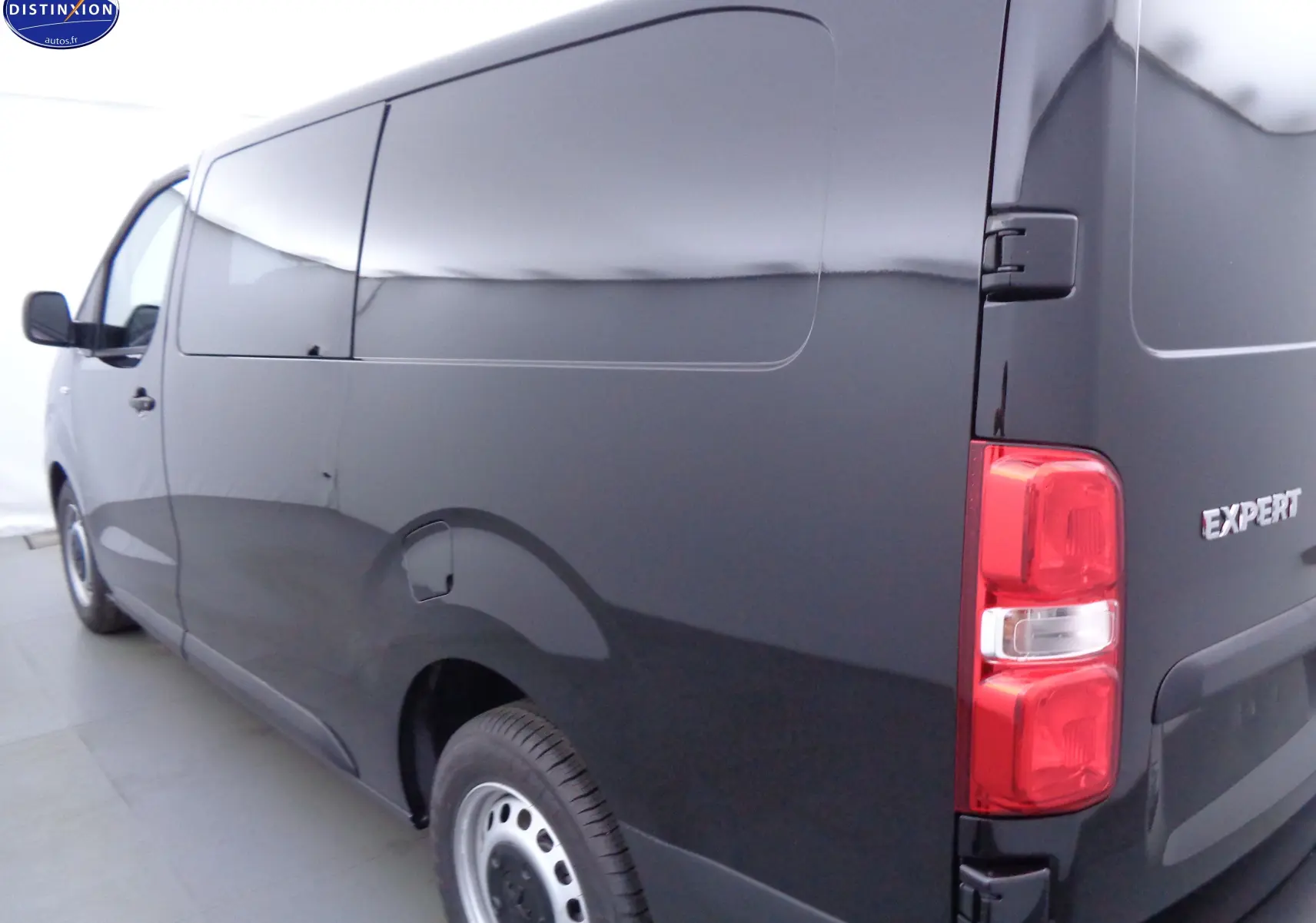 Vue 3/4 arrière droite du Peugeot Expert Long noir perle métal avec porte latérale coulissante et feux arrière rouges.