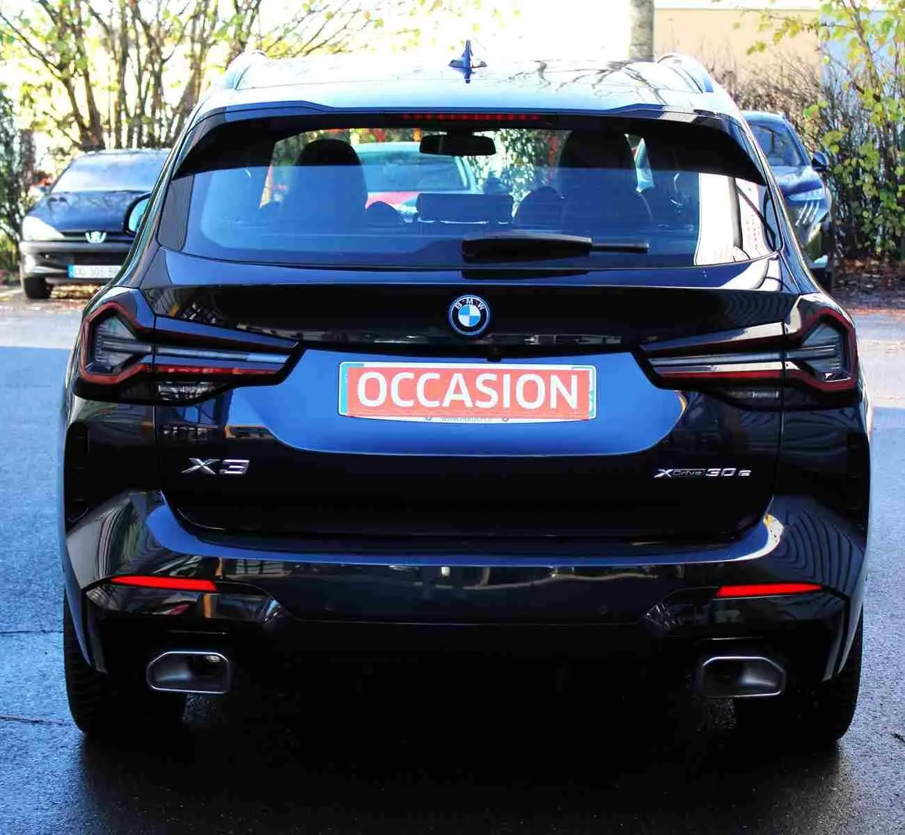 Vue arrière d’un BMW X3 xDrive 30e hybride rechargeable 2023 en bleu métal avec logo et feux LED distinctifs.