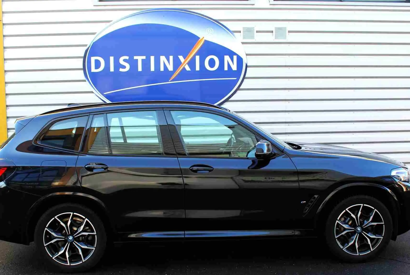 BMW X3 xDrive 30e 2023 en bleu métal, vue profil côté gauche avec jantes alliage M Sport distinctives.