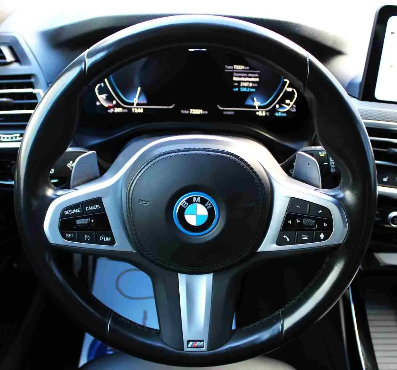 Vue rapprochée du volant M Sport en cuir noir du BMW X3 xDrive 30e hybride rechargeable 2023 avec commandes intégrées.