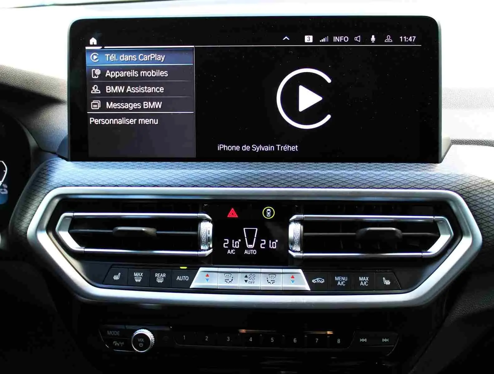 Tableau de bord du BMW X3 xDrive 30e 2023 avec écran tactile affichant CarPlay et commandes climatisation digitales.