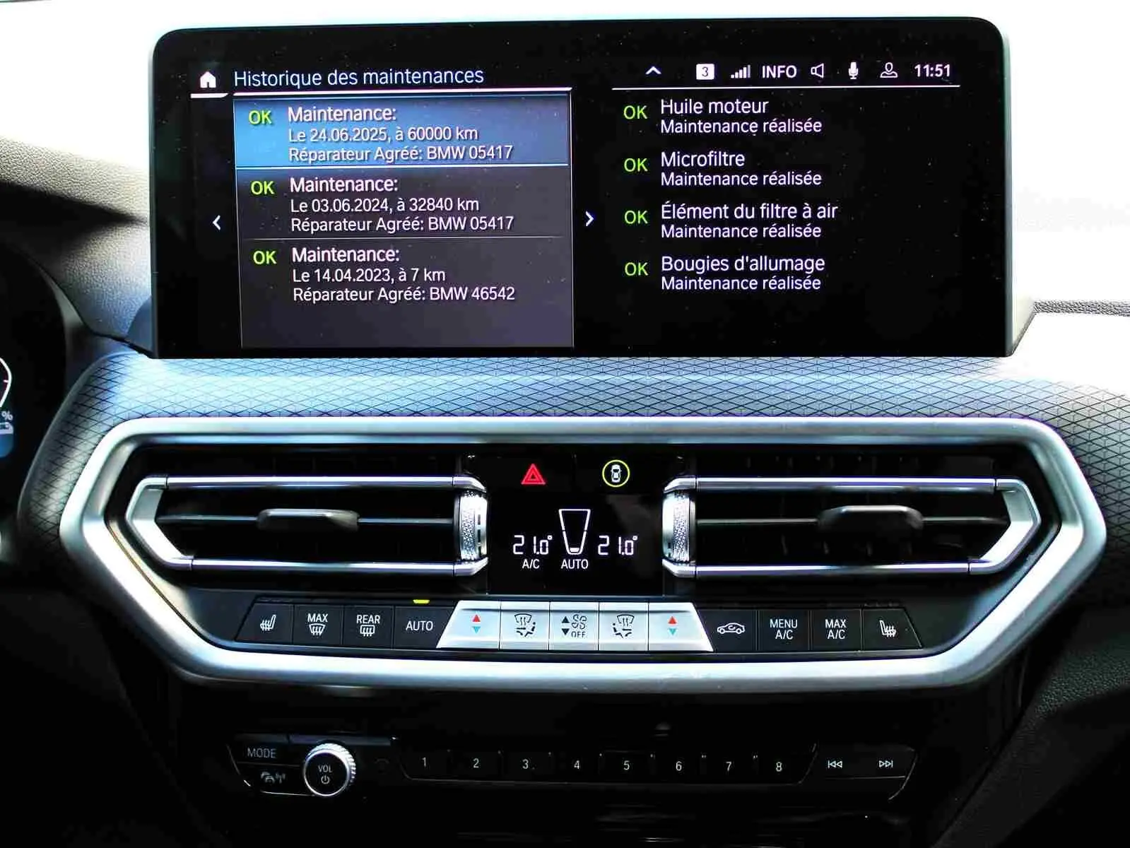 Tableau de bord du BMW X3 xDrive 30e 2023 avec écran multifonction et commandes climatisation visibles.