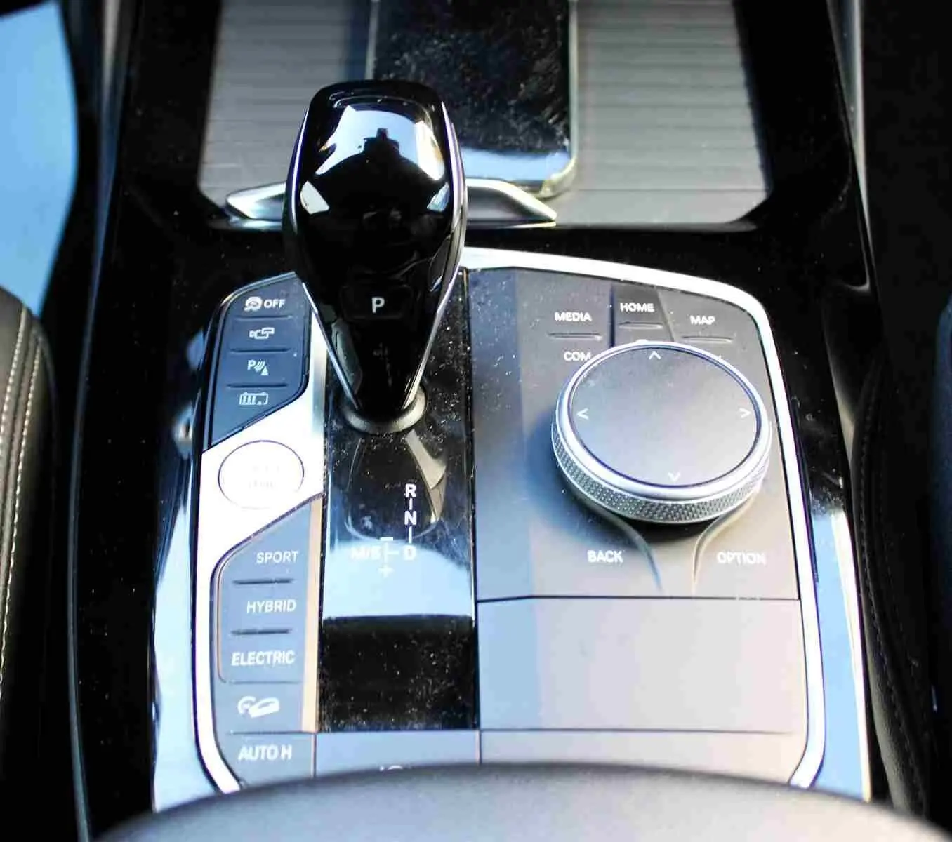 Gros plan sur la console centrale du BMW X3 xDrive 30e 2023, avec levier de vitesses et commandes hybrides visibles.