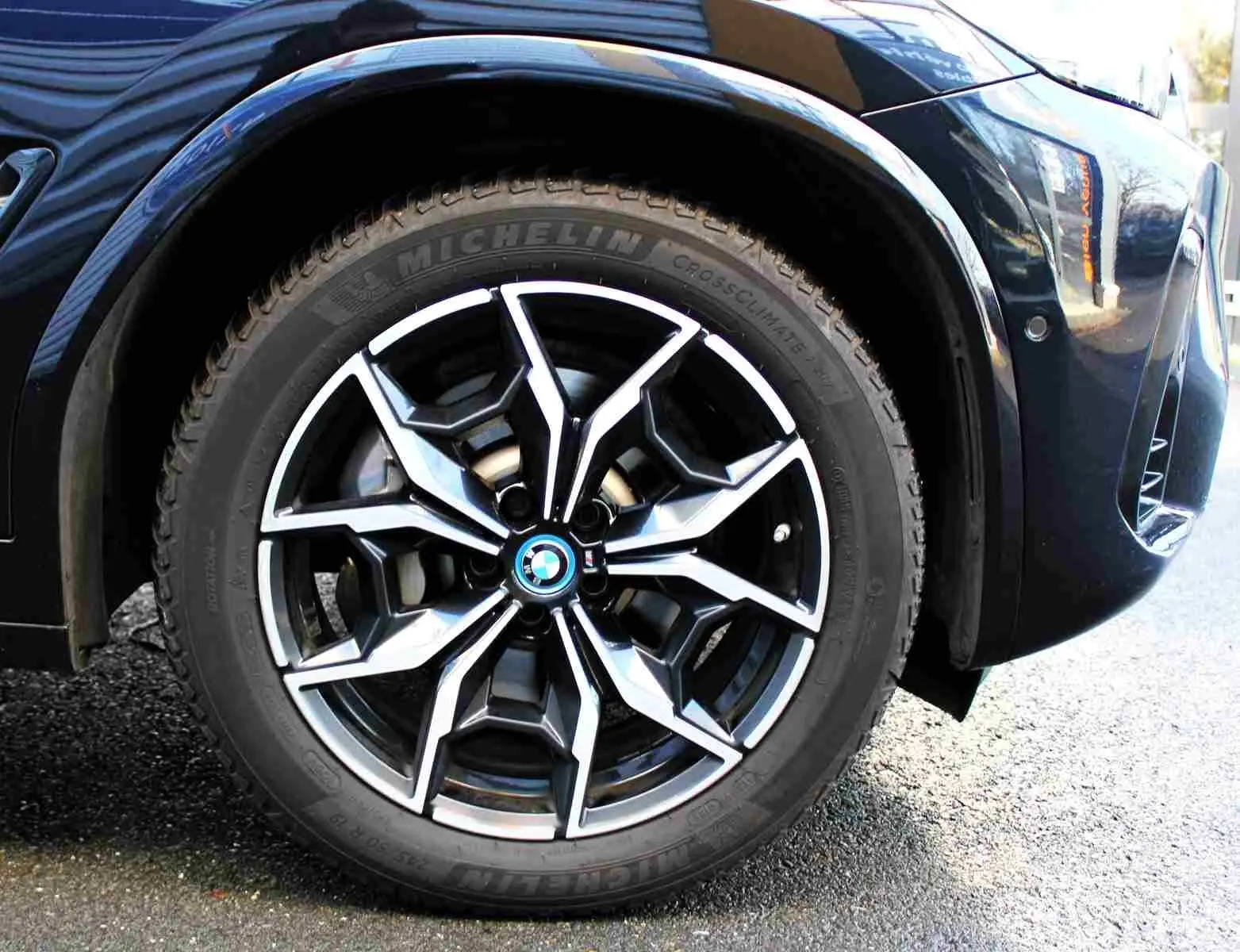 Gros plan sur la roue avant gauche du BMW X3 xDrive 30e 2023 bleu métal avec jante alliage au design sportif.