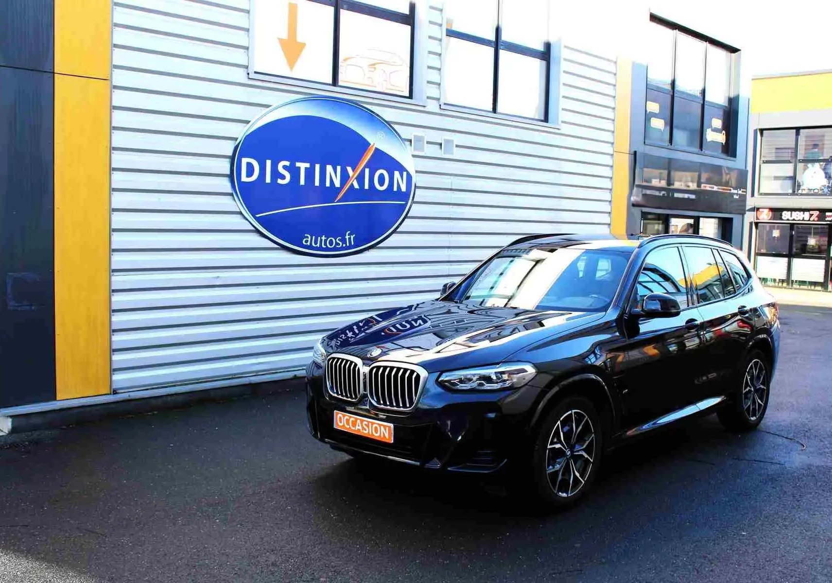 BMW X3 xDrive hybride rechargeable bleu métal vu en 3/4 avant droit avec calandre et jantes M Sport visibles