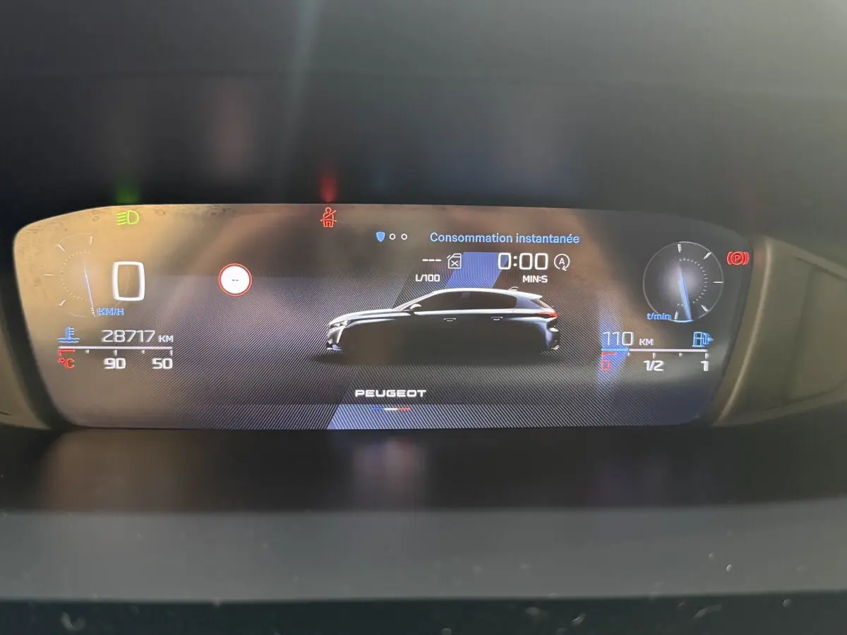 Affichage numérique du tableau de bord Peugeot 308 2023 avec silhouette latérale noire du véhicule et indicateurs de vitesse et carburant.