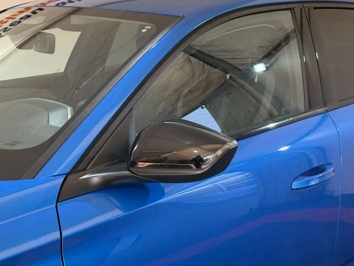 Gros plan sur le rétroviseur noir et la portière bleue côté conducteur de la Peugeot 308 PureTech 130 S&S Allure Pack 2023.