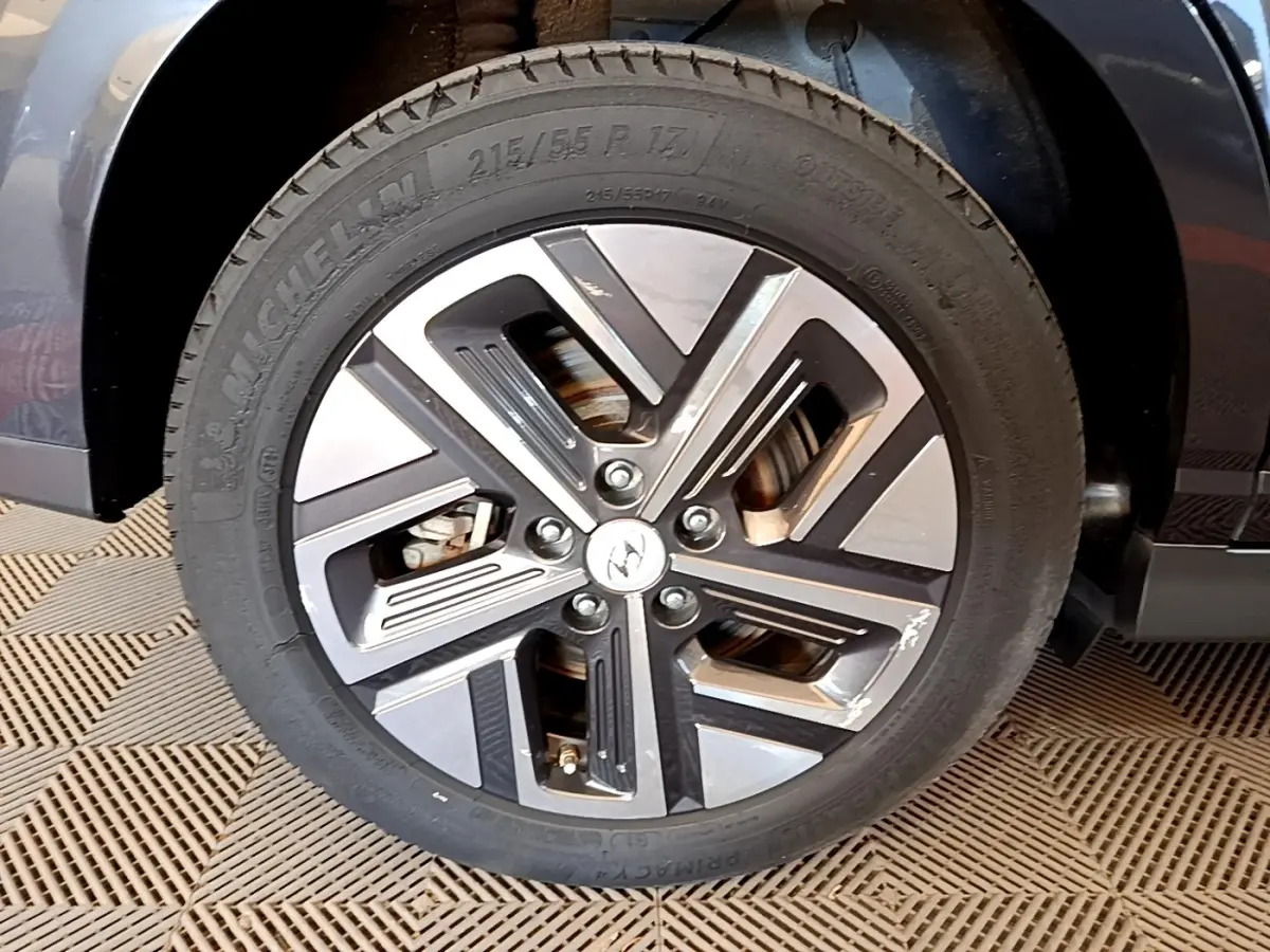 Gros plan sur la roue avant droite du Hyundai Kona électrique 2021, jante alliage bicolore avec logo Hyundai au centre.