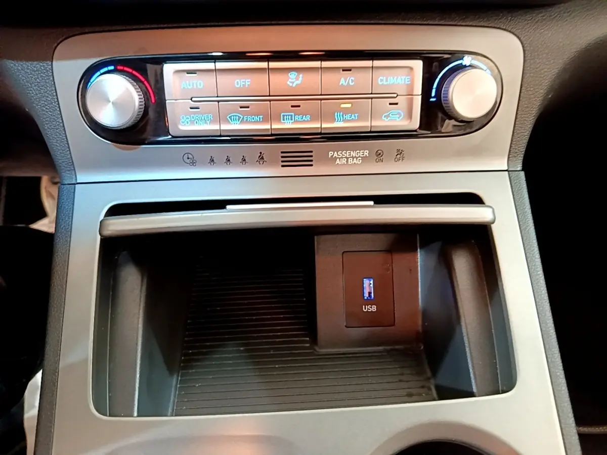 Détail de la console centrale du Hyundai Kona électrique 2021, avec commandes climatisation et port USB visible.