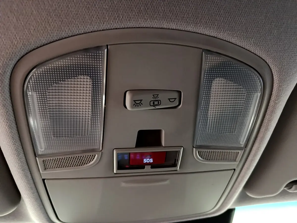 Plafonnier intérieur gris avec boutons d’éclairage et signal SOS du Hyundai Kona électrique, vue en contre-plongée.