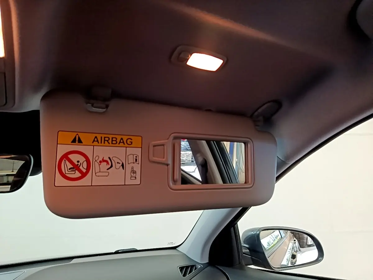 Vue intérieure du pare-soleil côté conducteur du Hyundai Kona électrique 2021 avec miroir et avertissement airbag.