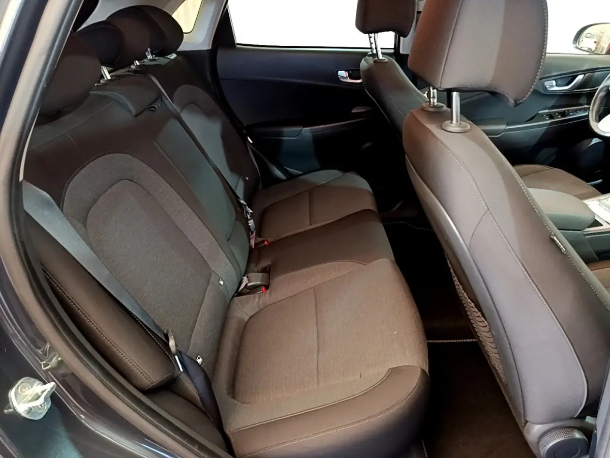Vue intérieure côté gauche montrant la banquette arrière grise et les sièges avant du Hyundai Kona électrique 2021.