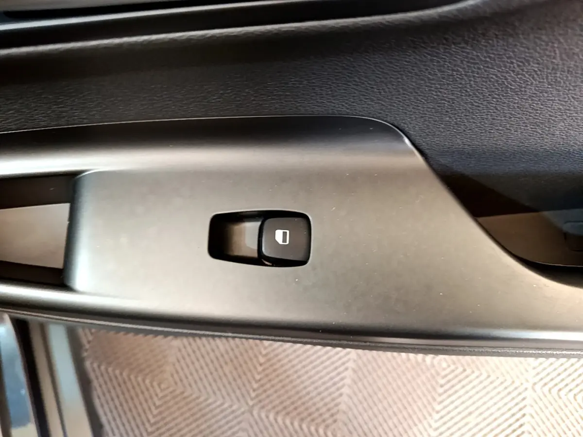 Gros plan sur le bouton de verrouillage des portes sur la portière intérieure noire d’un Hyundai Kona électrique 2021.