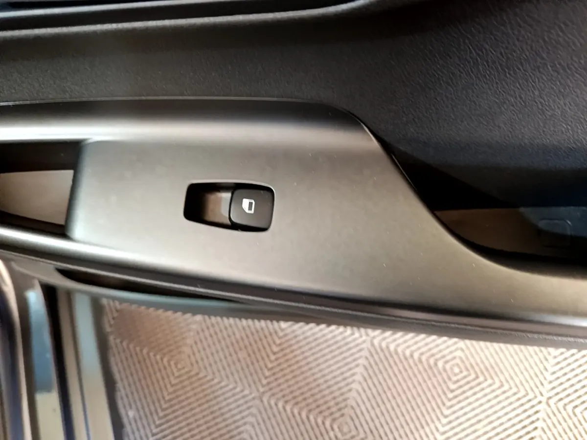 Gros plan sur le bouton de verrouillage des portes côté conducteur du Hyundai Kona électrique, intérieur noir.