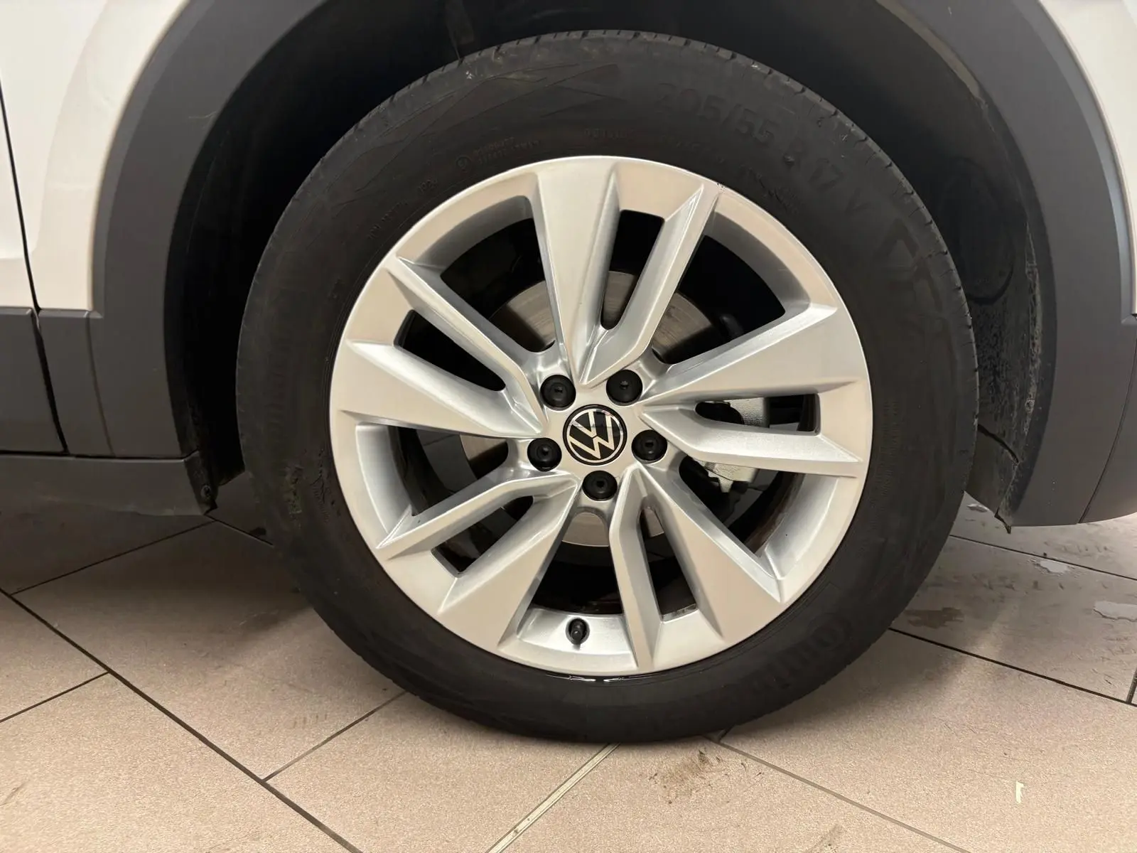 Gros plan sur la roue avant droite avec jante alliage argentée du Volkswagen T-Cross reflet d'argent 2024.