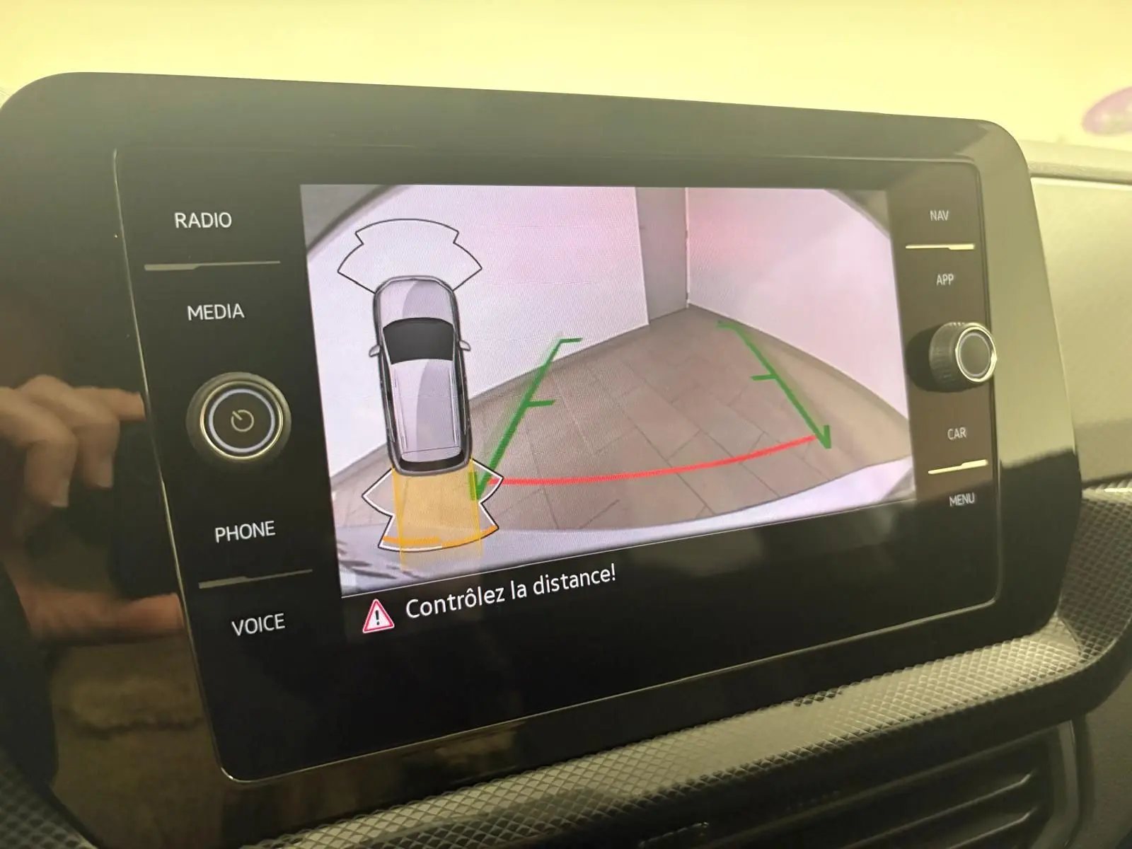 Écran tactile du Volkswagen T-Cross 2024 en reflet d'argent montrant la caméra de recul avec aides visuelles au stationnement.