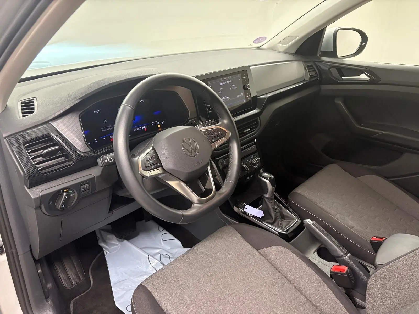 Intérieur avant droit du Volkswagen T-Cross 2024 argent, volant cuir multifonction et écran tactile central.